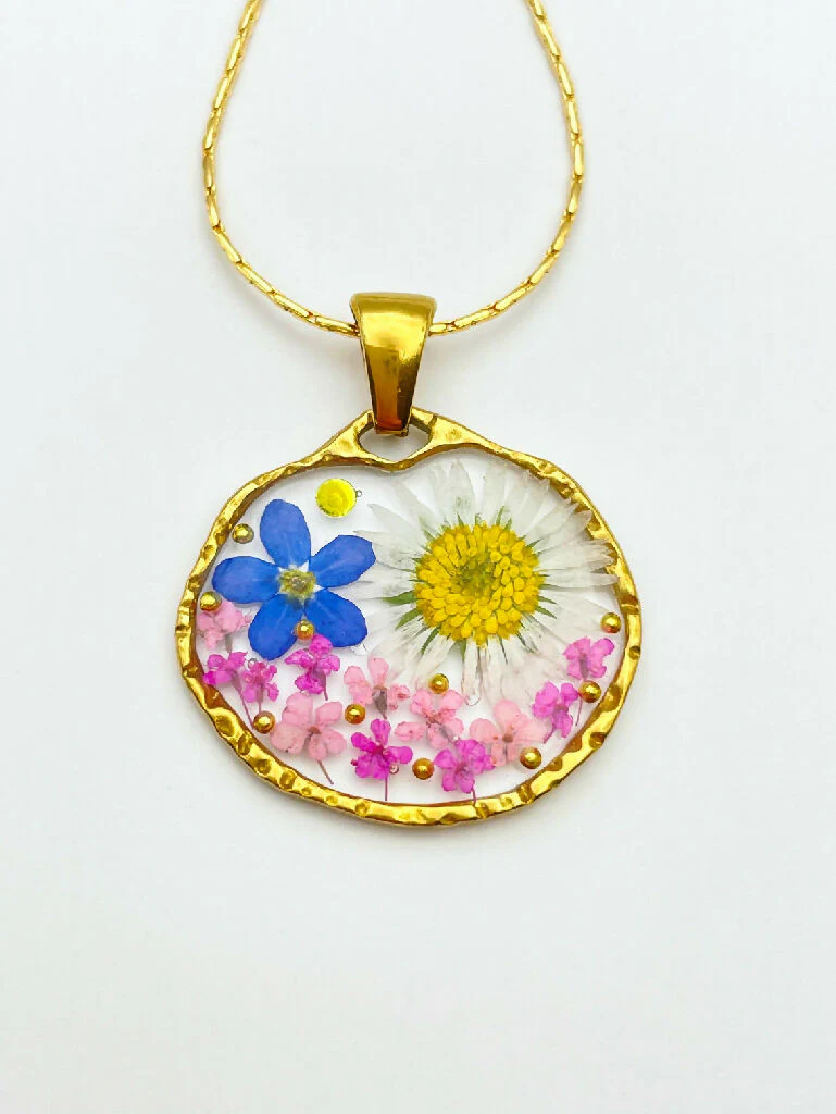 Pendant necklace with daisy and forget me not flowers