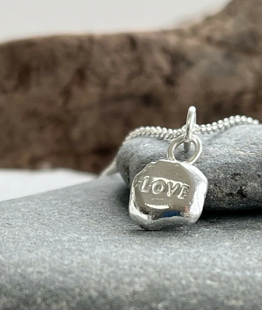A recycled silver ‘LOVE’ stamped pebble pendant necklace
